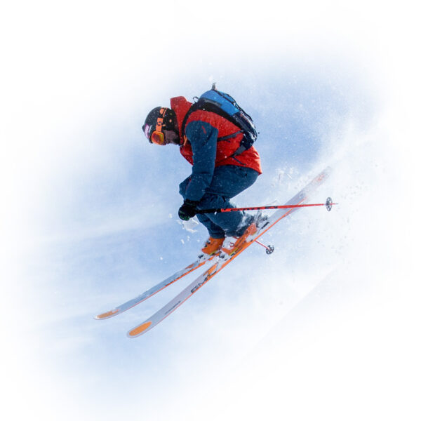 Isolated image of powder skier catching air at Gold Rush Heli Skiing