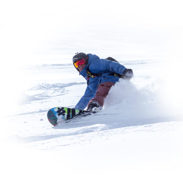 Isolated image of snowboarder turning in deep powder at Gold Rush Heli Skiing