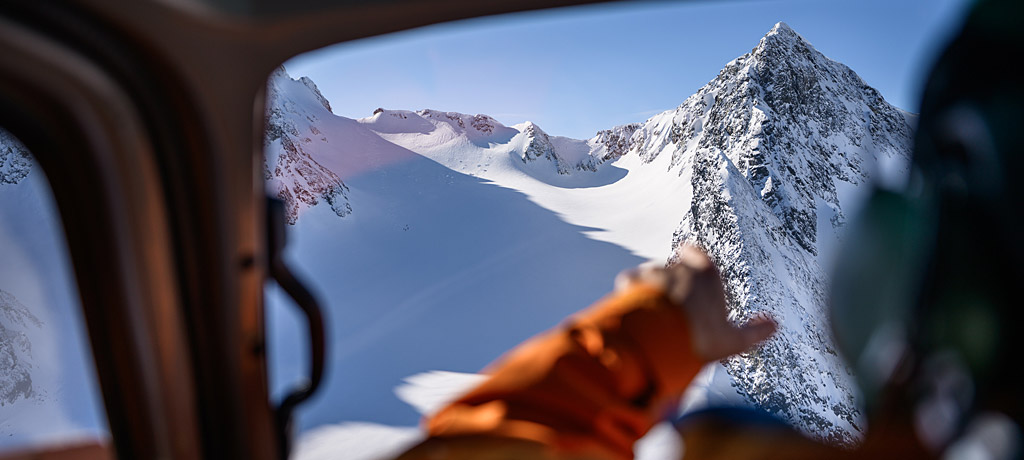 safety-inset Guide points to snow bowl from inside helicopter